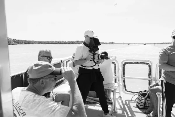 Professional video production team filming on location in Southwest Florida during golden hour with camera, lighting, and drone setup